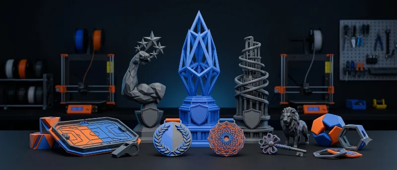 Trofeos, medallas y placas impresos en 3D sobre la mesa del taller, en azul y gris